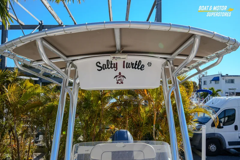 Slide: The Image of 2019 Tidewater 198 CC Adventure boat with "Salty Turtle" sign, parked outdoors. - 35