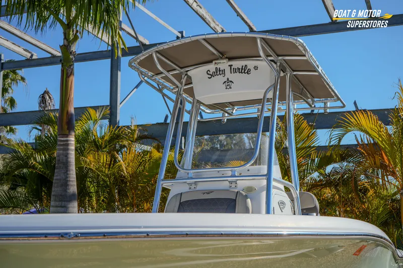 Slide: The Image of 2019 Tidewater 198 CC Adventure boat with T-top, surrounded by tropical foliage. - 4