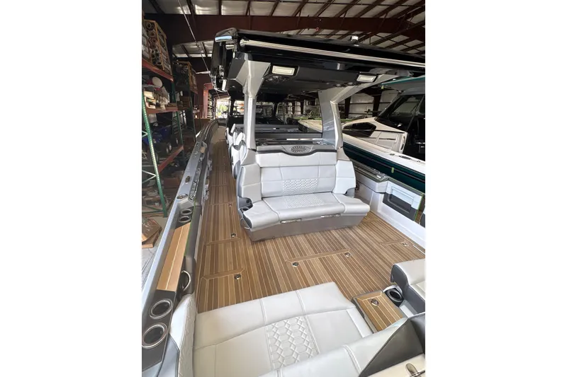 Slide: The Image of 2024 Nor-Tech boat interior with luxurious seating and wood-style flooring in a showroom. - 11