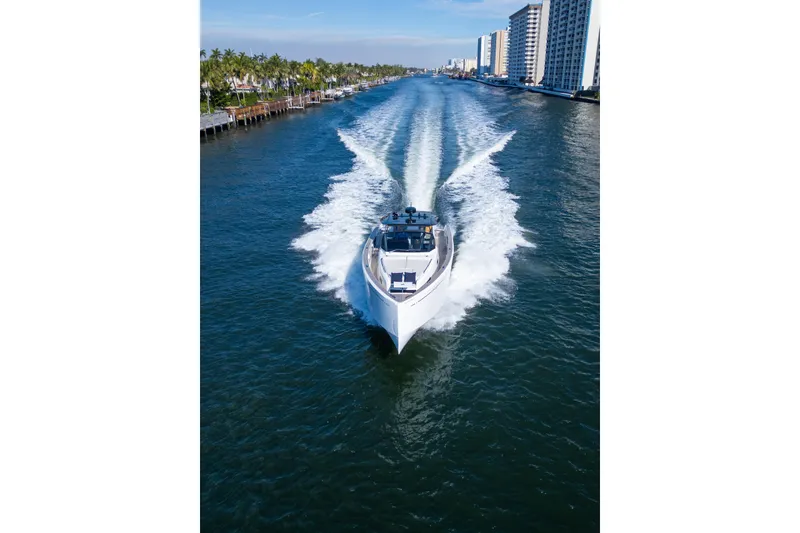 Slide: The Image of 2019 Pardo Yachts cruising through a scenic waterway with cityscape and palm trees. - 12