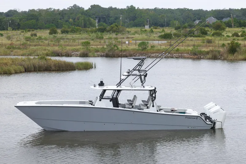 The Image of 2026 Freeman 42 boat on calm water, surrounded by lush greenery. - 1