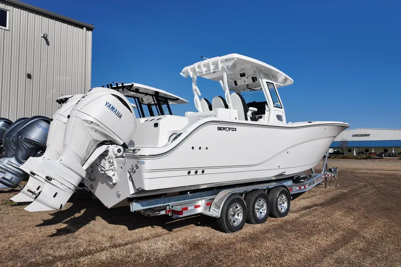 Slide: The Image of 2026 Sea Fox 328 Commander boat on trailer, featuring Yamaha engines, parked outdoors. - 1