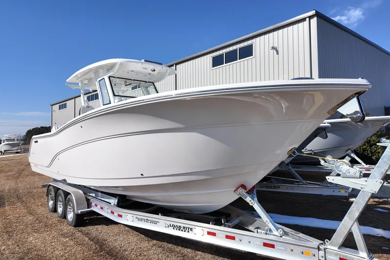 Slide: The Image of 2026 Sea Fox 328 Commander boat on trailer, parked outdoors near a building. - 3