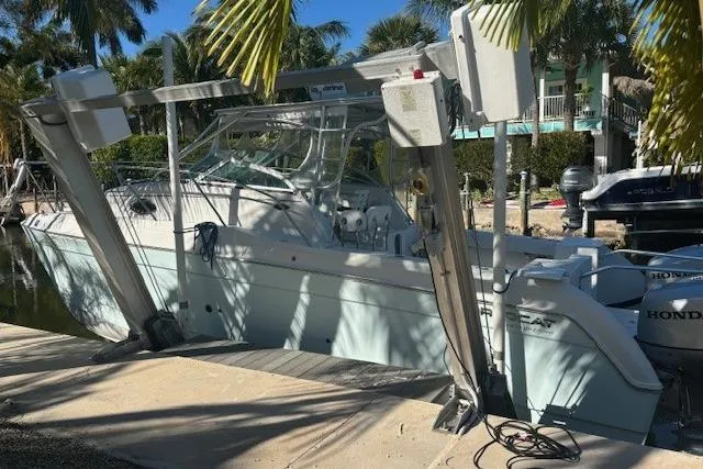The Image of 2008 Glacier Bay 2670 Cuddy boat docked, surrounded by palm trees. - 0