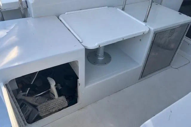 Slide: The Image of 2008 Glacier Bay 2670 Cuddy boat interior with storage compartment and table. - 21