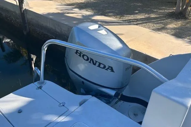 Slide: The Image of 2008 Glacier Bay 2670 Cuddy with Honda outboard motor docked by canal. - 27