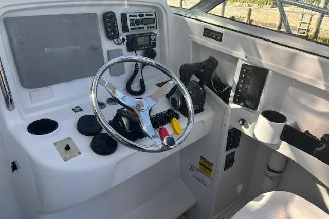 Slide: The Image of 2008 Glacier Bay 2670 Cuddy boat helm with steering wheel and navigation controls. - 5