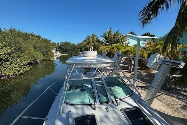 Slide: The Image of 2008 Glacier Bay 2670 Cuddy boat docked by a tropical canal under clear blue skies. - 7