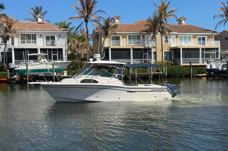 The Image of 2009 Grady-White Marlin 300 boat cruising near waterfront homes. - 0