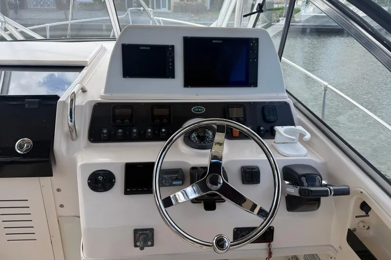 Slide: The Image of 2009 Grady-White Marlin 300 helm with steering wheel and navigation controls. - 11