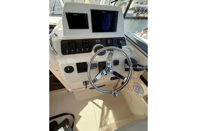 Slide: The Image of 2009 Grady-White Marlin 300 helm with dual Simrad displays and chrome steering wheel. - 12