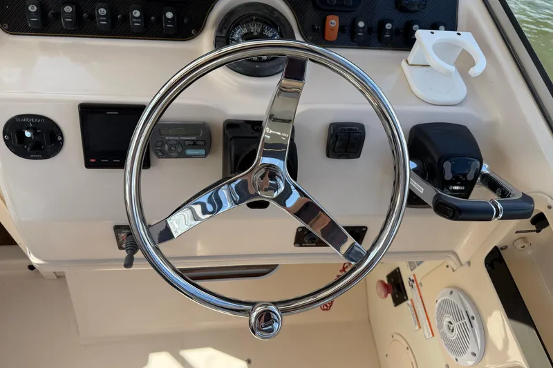 Slide: The Image of 2009 Grady-White Marlin 300 helm with steering wheel and control panel. - 13