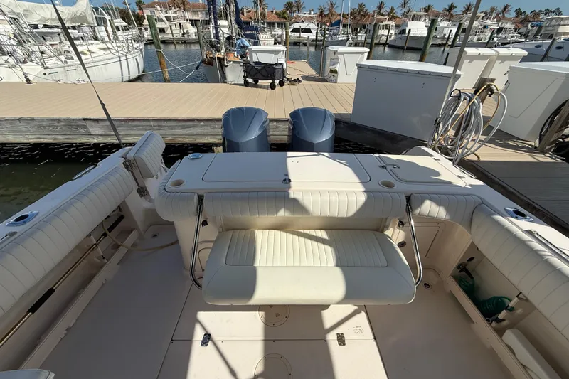 Slide: The Image of 2009 Grady-White Marlin 300 boat interior at marina dock, featuring seating and twin engines. - 28