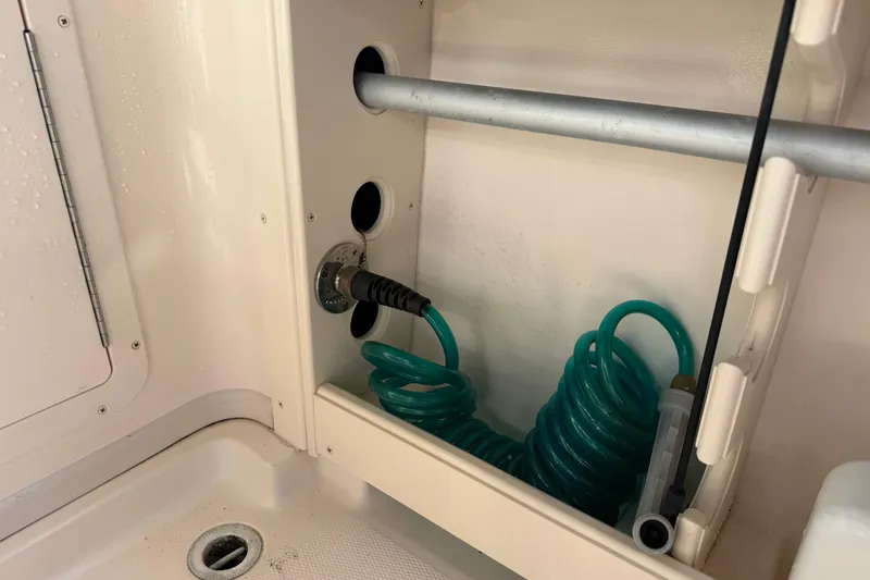 Slide: The Image of 2009 Grady-White Marlin 300 boat interior with coiled hose and storage compartment. - 32