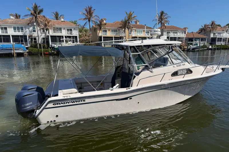 Slide: The Image of 2009 Grady-White Marlin 300 boat on water, with Yamaha engines, near waterfront homes. - 4