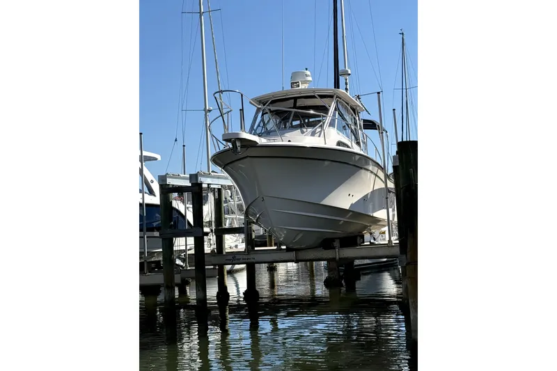 Slide: The Image of 2009 Grady-White Marlin 300 boat docked at a marina, viewed from the front. - 6