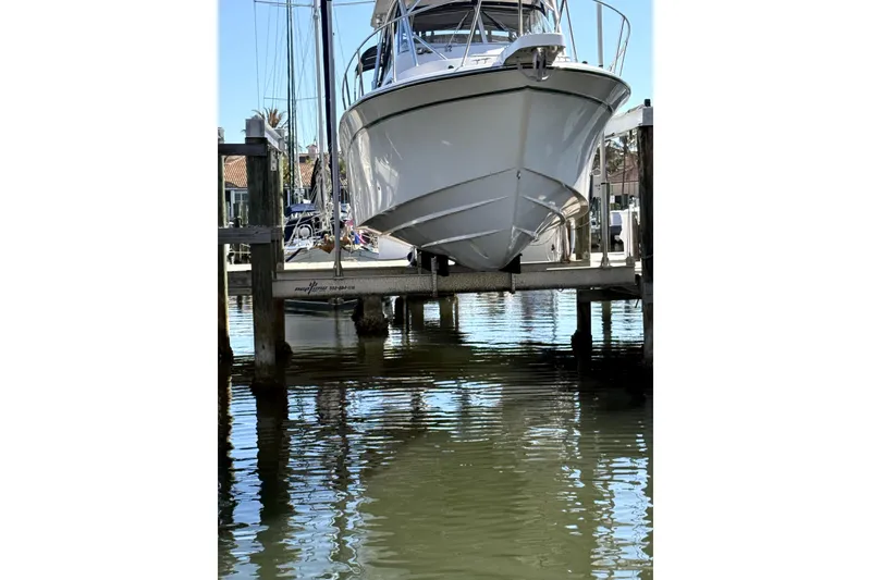 Slide: The Image of 2009 Grady-White Marlin 300 boat docked at marina, reflecting on calm water. - 7