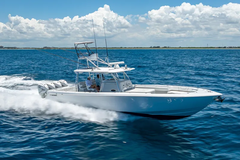 The Image of 2021 Contender 44 CB boat cruising on open blue ocean under clear sky. - 0