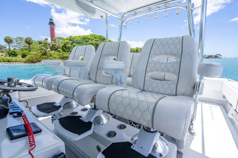 Slide: The Image of Contender 44 CB 2021 boat interior with luxurious seating, ocean view, and lighthouse in background. - 12