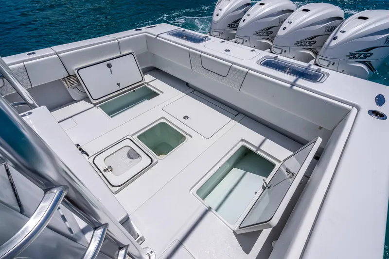 Slide: The Image of 2021 Contender 44 CB boat deck with open storage compartments and four powerful outboard engines. - 22
