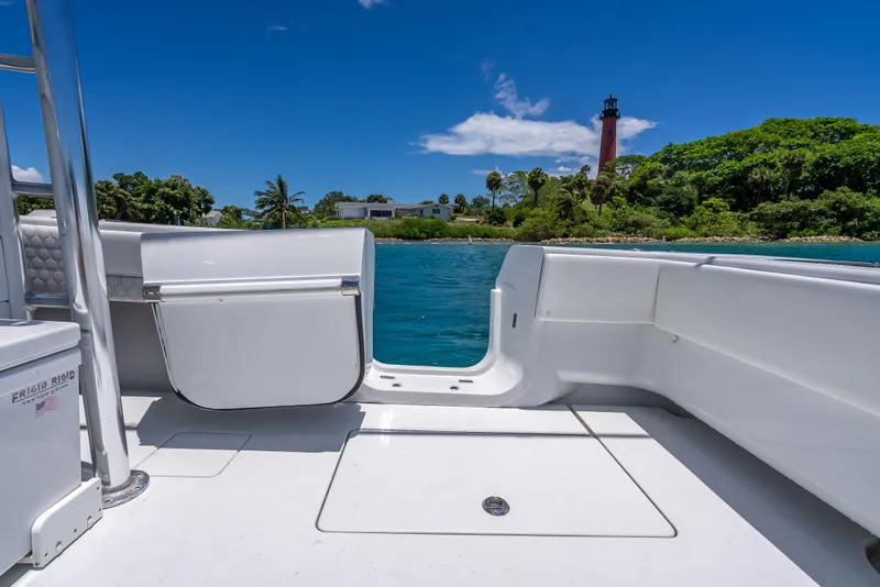 Slide: The Image of Contender 44 CB boat deck with scenic lighthouse and lush greenery in the background. - 23