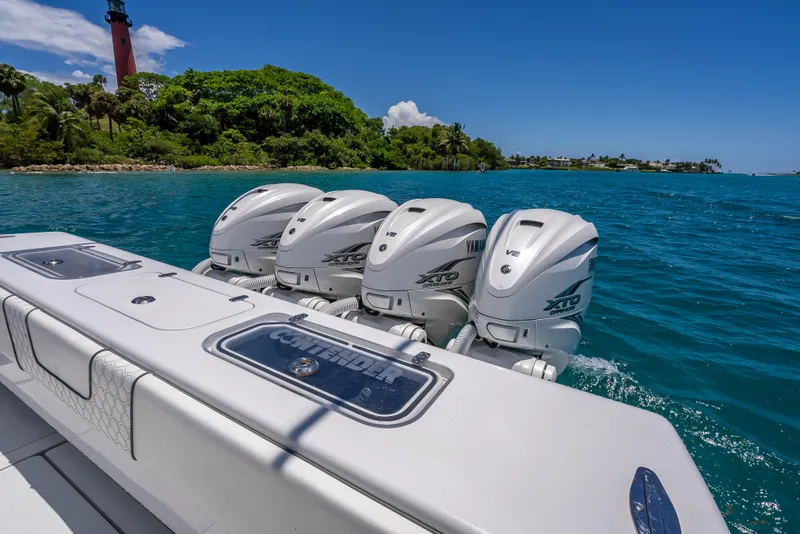 Slide: The Image of Contender 44 CB 2021 boat with four powerful outboard engines on blue water. - 24