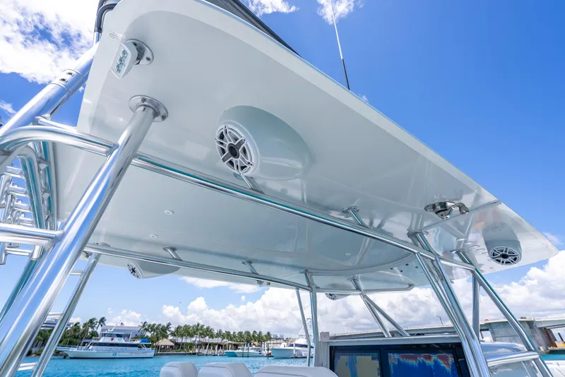 Slide: The Image of 2021 Contender 44 CB boat with sleek canopy and speakers, set against a clear blue sky. - 25