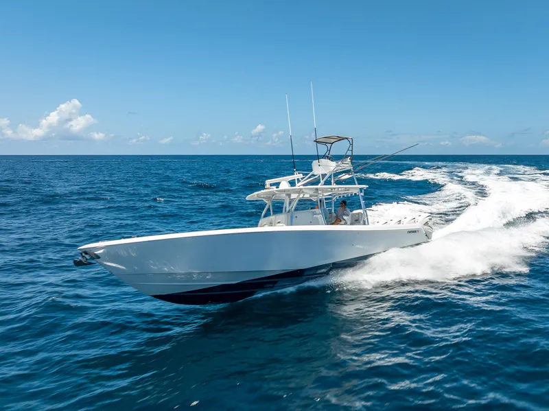 Slide: The Image of 2021 Contender 44 CB boat cruising on open ocean under clear blue sky. - 3