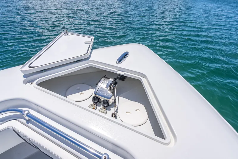 Slide: The Image of 2021 Contender 44 CB boat anchor compartment with open hatch on calm water. - 32