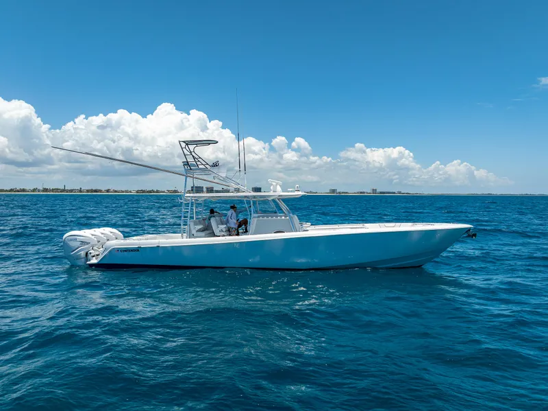 Slide: The Image of 2021 Contender 44 CB boat cruising on open ocean under clear blue sky. - 38