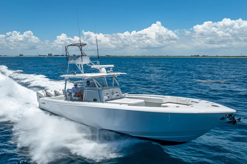 Slide: The Image of 2021 Contender 44 CB boat cruising on open water under a clear blue sky. - 46