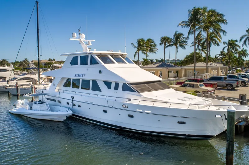 The Image of 2003 Hargrave Skylounge yacht docked at marina with palm trees and clear blue sky. - 0