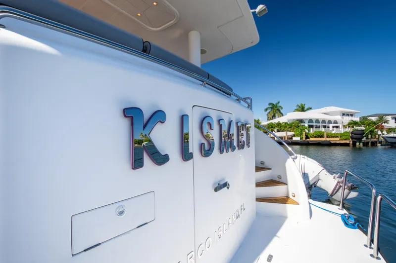 Slide: The Image of 2003 Hargrave Skylounge yacht "Kismet" docked by waterfront homes, clear blue sky. - 10
