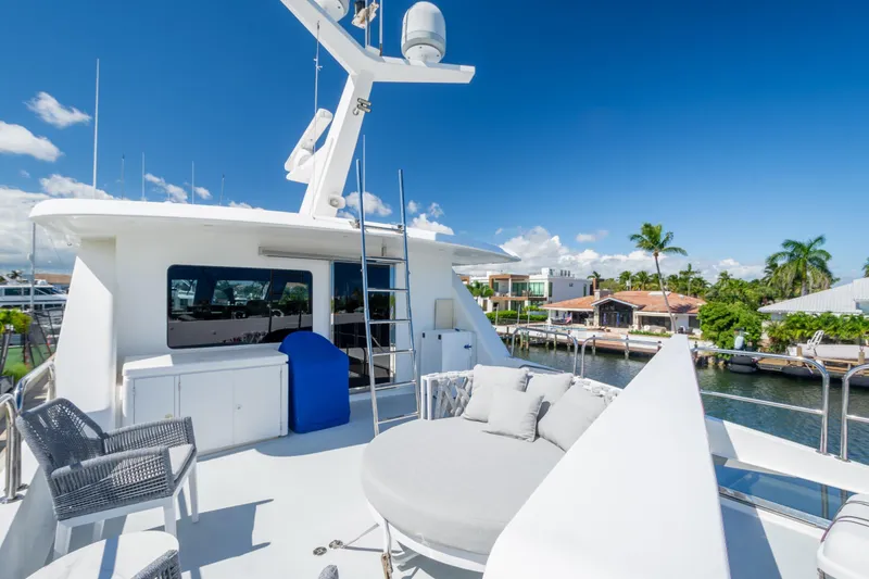 Slide: The Image of 2003 Hargrave Skylounge yacht deck with seating, overlooking waterfront homes and palm trees. - 6