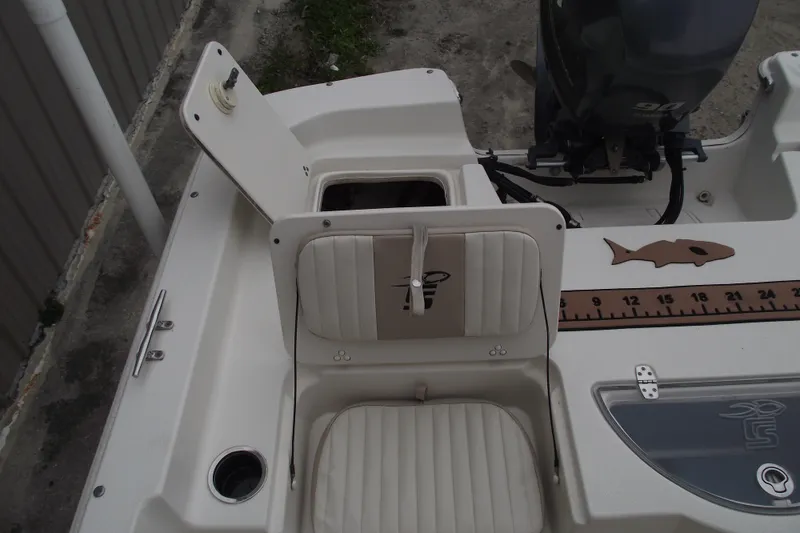 Slide: The Image of 2016 Carolina Skiff 198 DLV boat interior with open storage compartment and measuring ruler. - 20