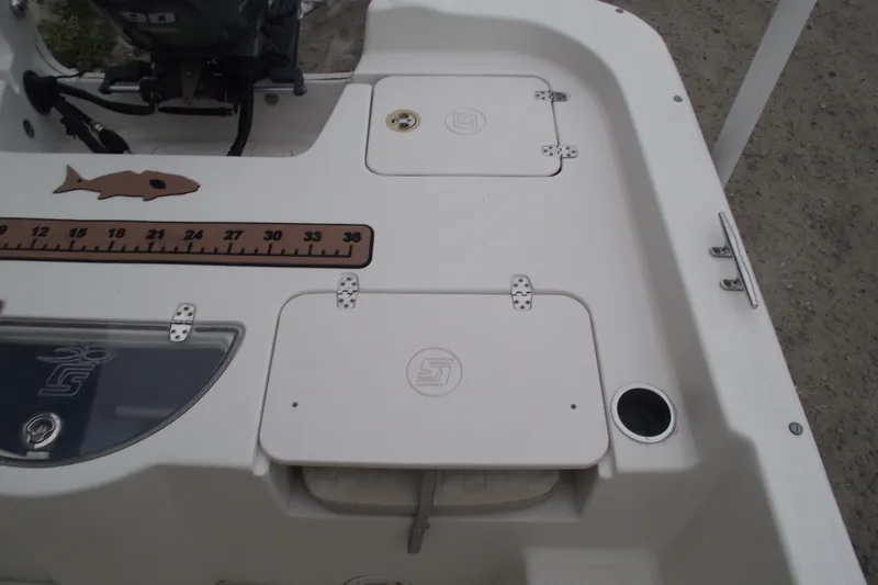 Slide: The Image of 2016 Carolina Skiff 198 DLV boat deck with storage compartments and fish ruler. - 23