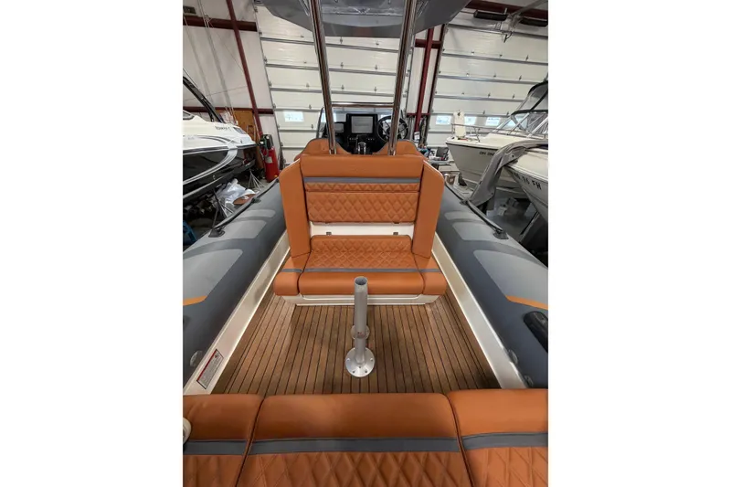 Slide: The Image of 2023 Cobra Ribs Nautique 8.2m boat interior with brown leather seating and wood flooring. - 12