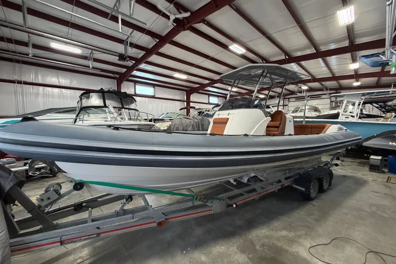 Slide: The Image of 2023 Cobra Ribs Nautique 8.2m boat in a storage facility on a trailer. - 2