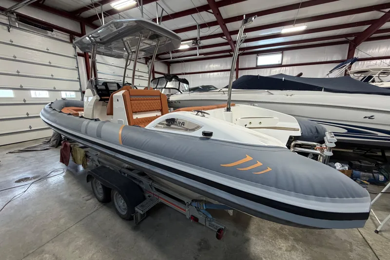 Slide: The Image of 2023 Cobra Ribs Nautique 8.2m boat in a garage, featuring sleek design and orange seating. - 3