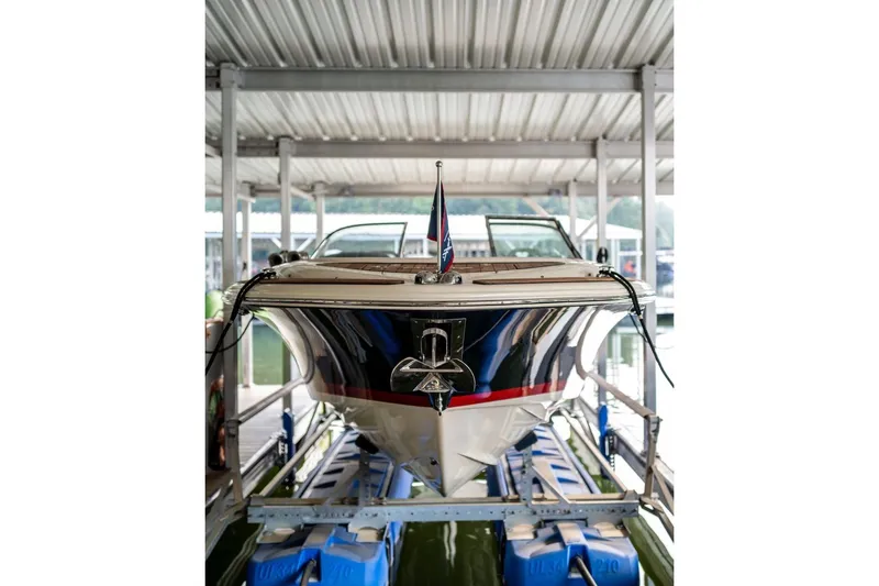Slide: The Image of 2023 Chris-Craft Launch 27 boat docked in a covered marina. - 1