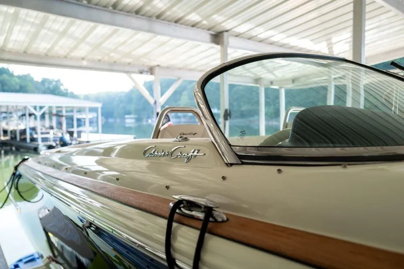 Slide: The Image of 2023 Chris-Craft Launch 27 boat docked under a covered marina. - 4