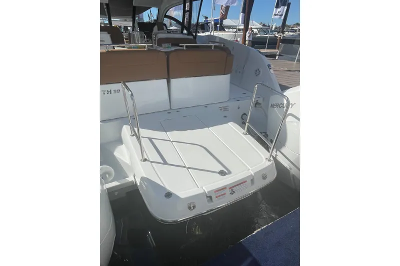 Slide: The Image of 2026 Jeanneau TH38 boat with spacious deck and Mercury engine at a marina. - 11