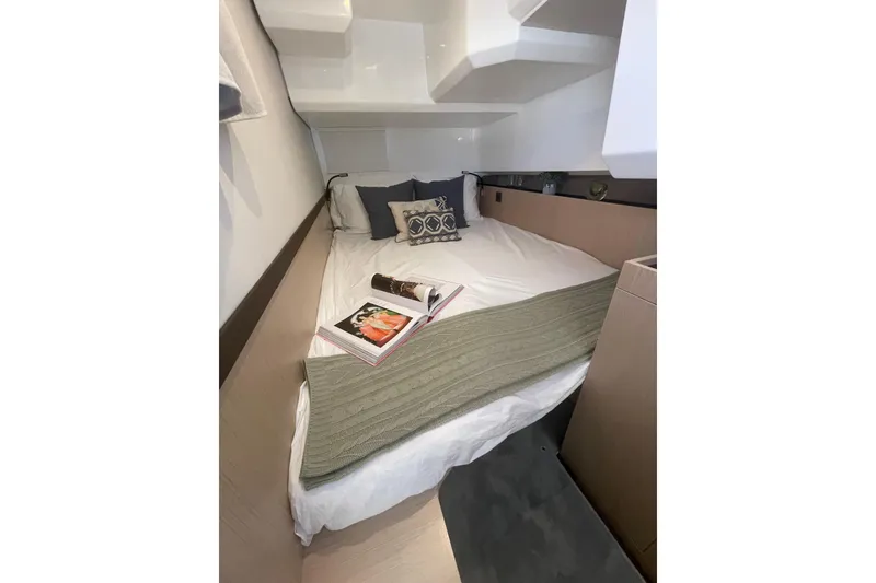 Slide: The Image of Cozy cabin interior of 2026 Jeanneau TH38 yacht with bed and magazines. - 40
