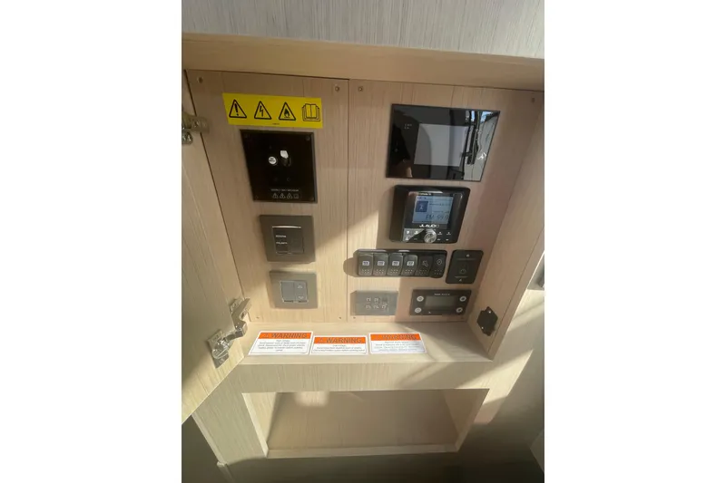 Slide: The Image of Control panel of 2026 Jeanneau TH38 boat with various switches and warnings. - 42