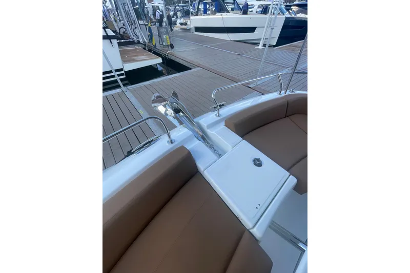 Slide: The Image of 2026 Jeanneau TH38 boat interior with brown seating and dock view. - 52