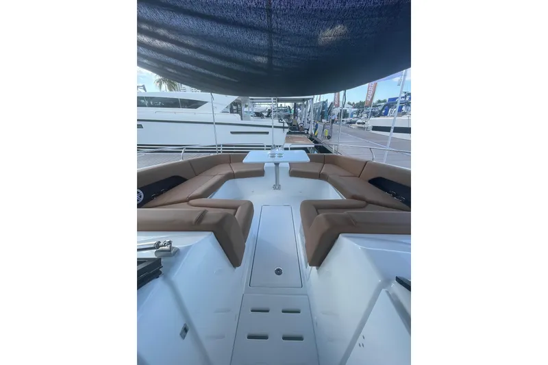 Slide: The Image of 2026 Jeanneau TH38 yacht interior with brown seating and table under canopy. - 55
