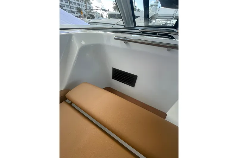 Slide: The Image of Interior view of 2026 Jeanneau TH38 boat with tan seating and window. - 63