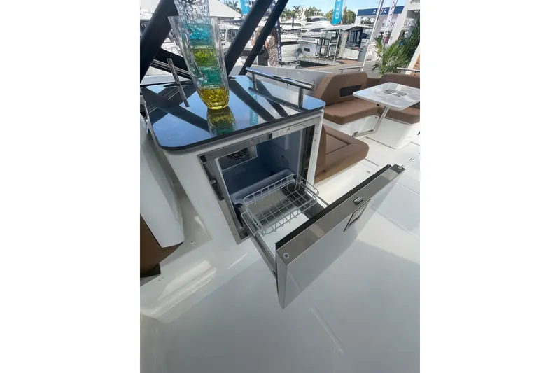 Slide: The Image of 2026 Jeanneau TH38 yacht interior with open drawer fridge and seating area. - 74