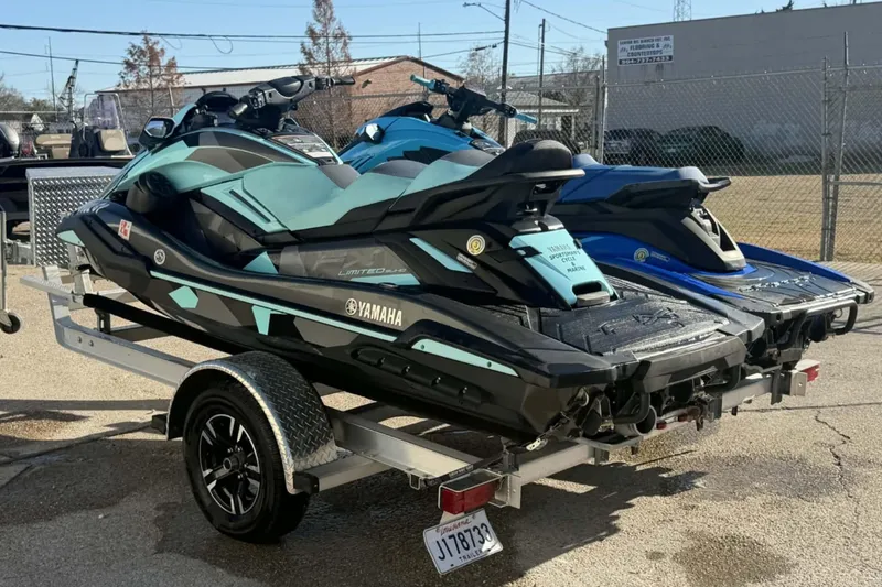 Slide: The Image of 2023 Yamaha WaveRunner GP1800R SVHO jet skis on a trailer in a parking lot. - 7