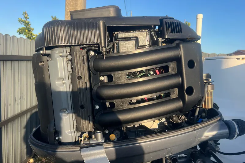 Slide: The Image of Close-up of a 2011 Wellcraft 232 Coastal boat engine in a sunny outdoor setting. - 11